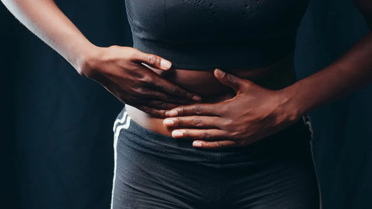 Pessoa com a mão na barriga, destacando ilustração de dor no intestino e desconforto abdominal