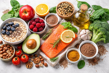 Alimentos que ajudam a baixar o colesterol LDL, como salmão, aveia, abacate, castanhas, frutas vermelhas, azeite de oliva e vegetais frescos dispostos sobre a mesa.