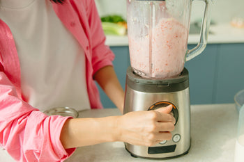 mulher preparando uma vitamina no liquidificador